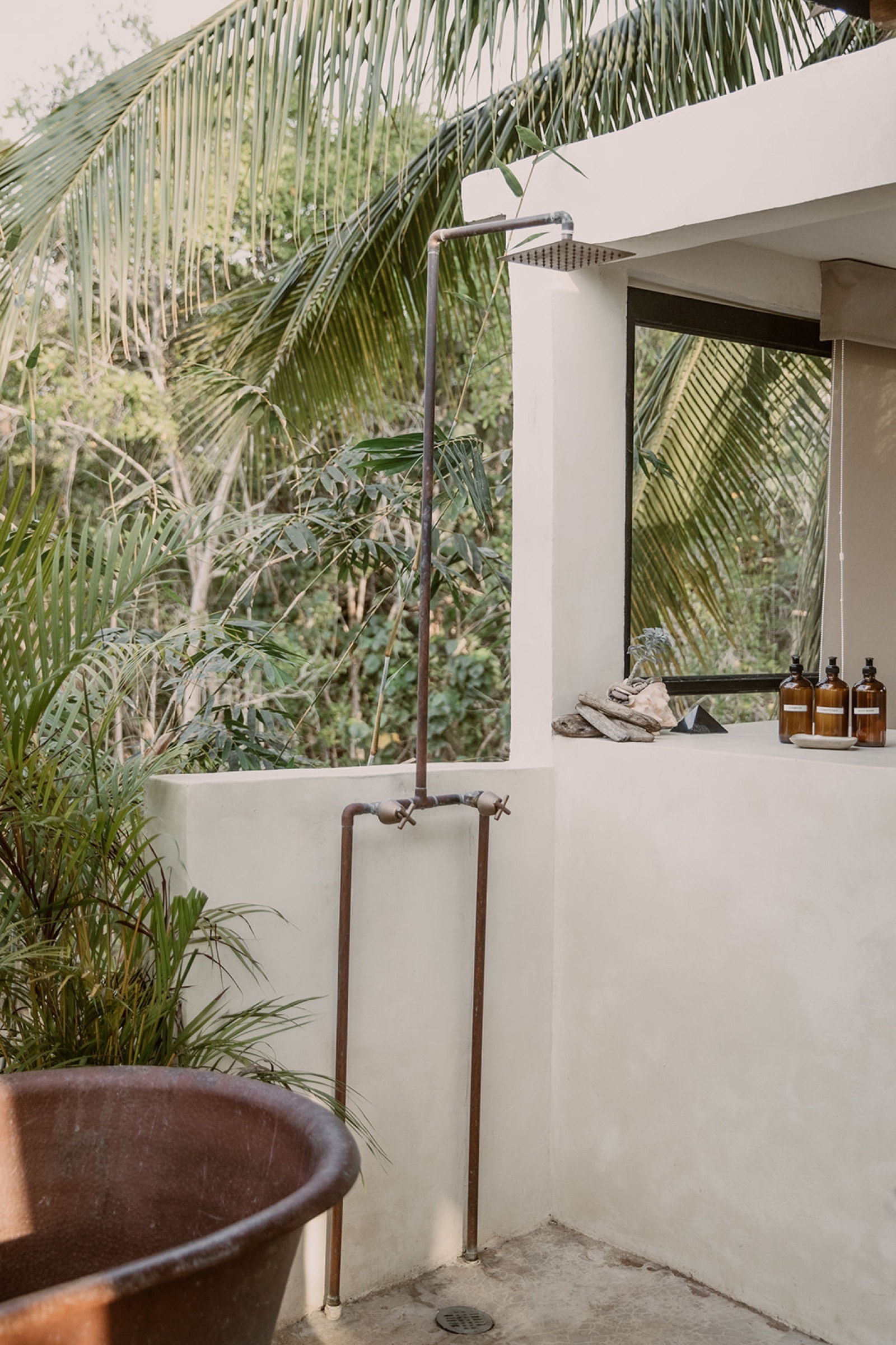 Outdoor shower with copper tub and palms