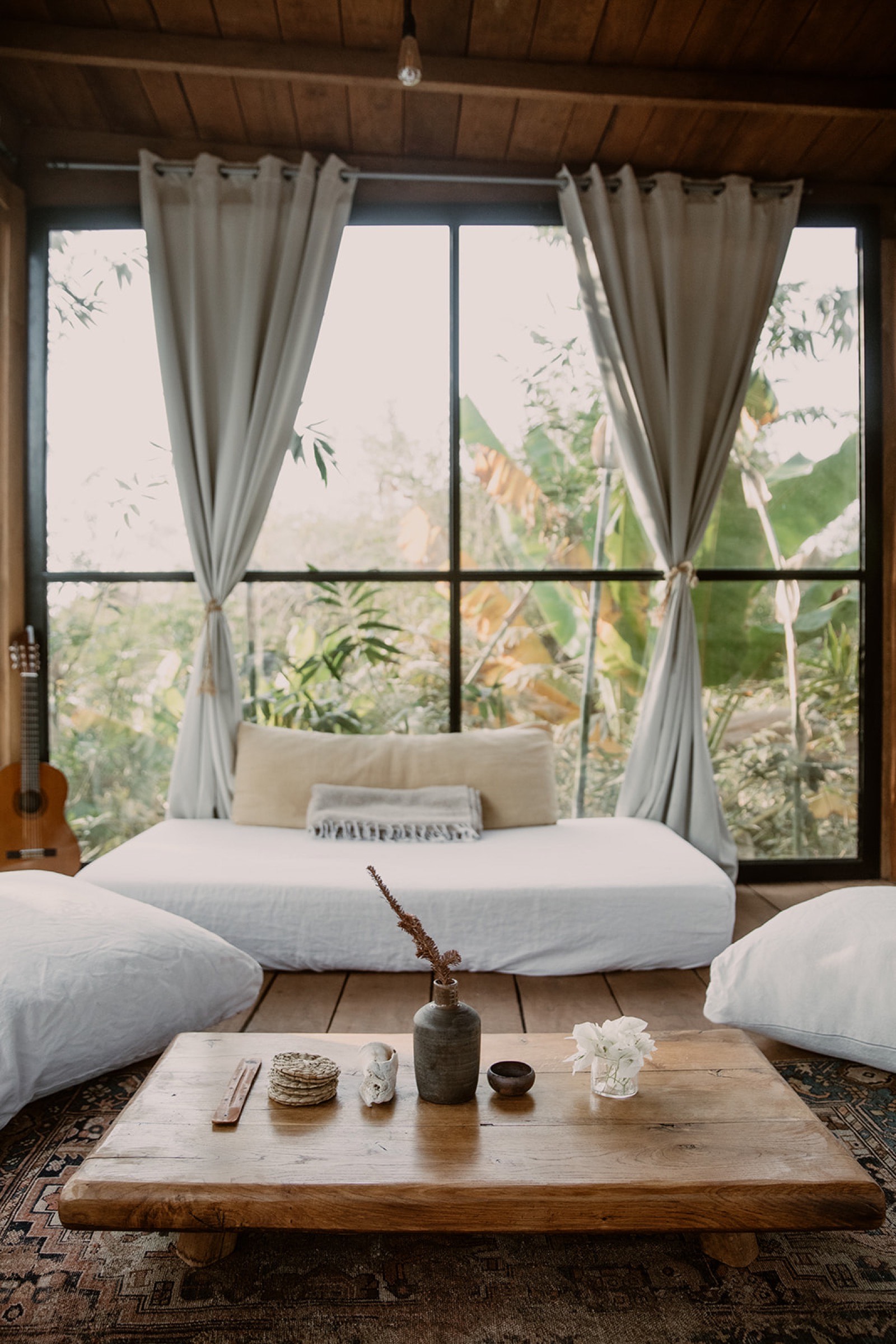 Treehouse daybed with ukulele, coffee table, curtains