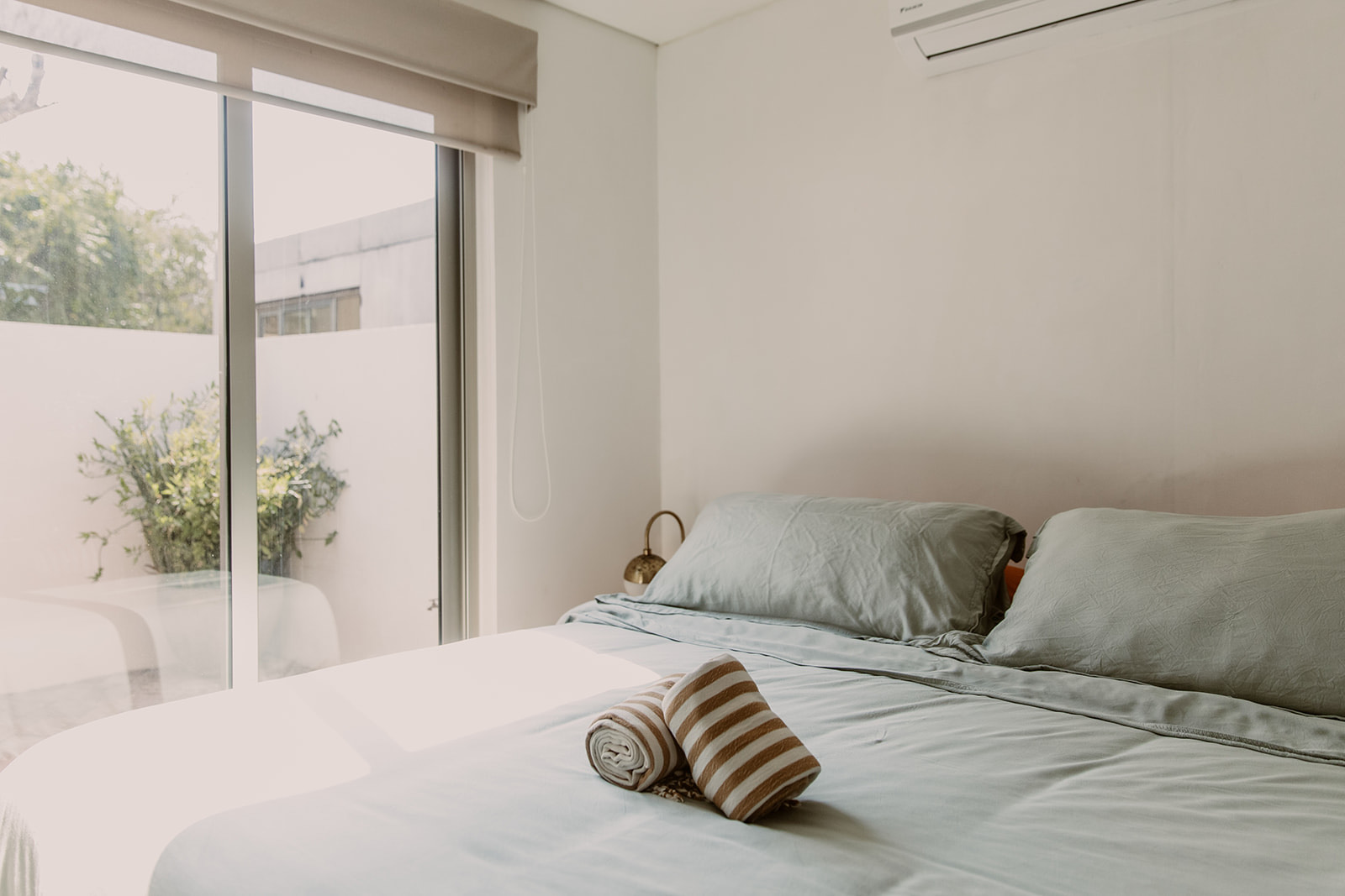 La Casita Grande bedroom with courtyard view through glass